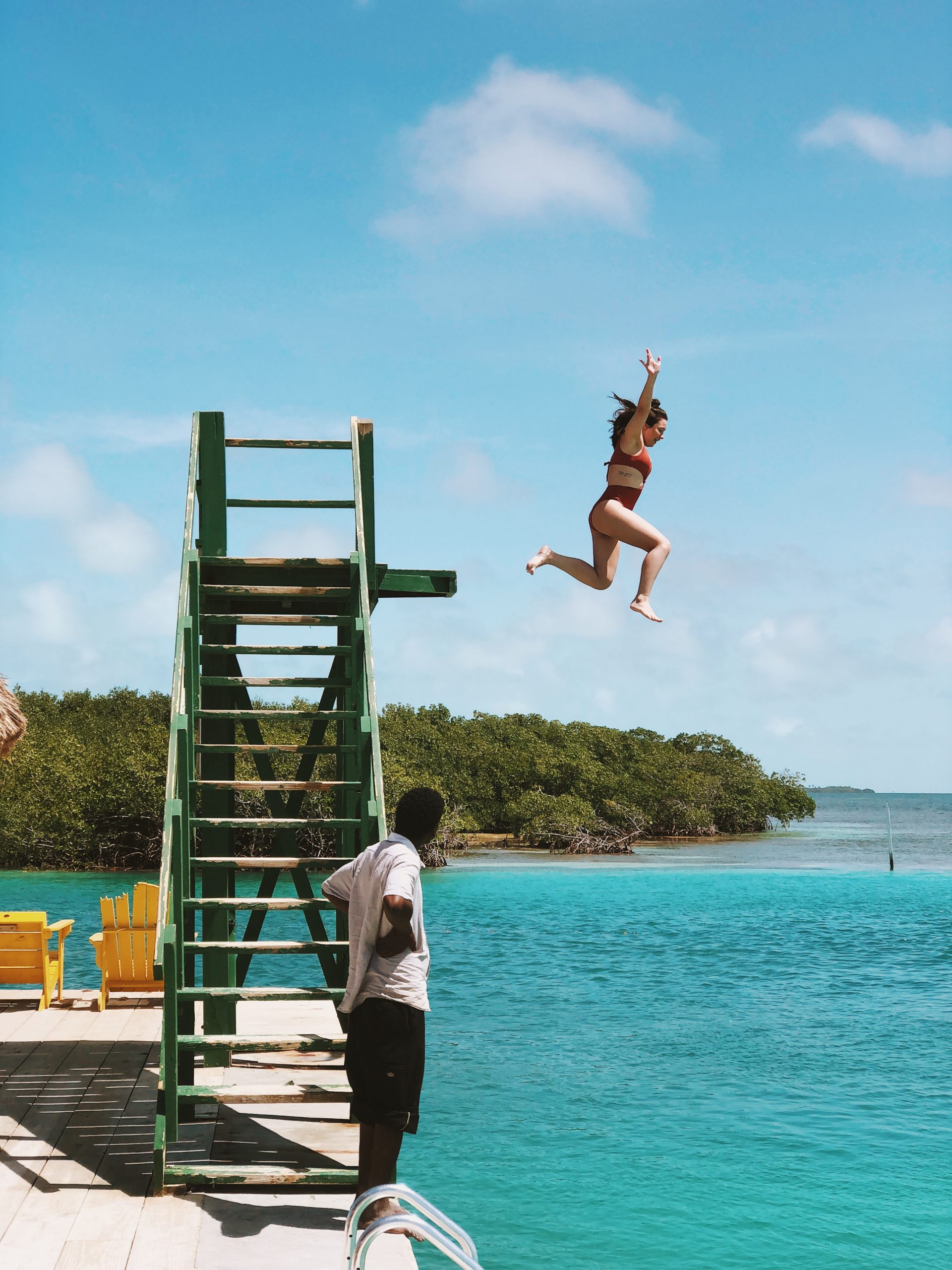 Girl jumping off ladder into ocean