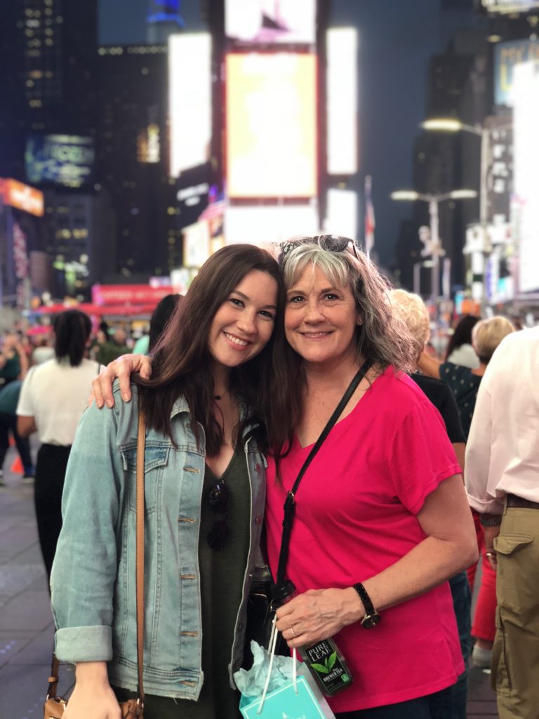 two women smiling in times square
