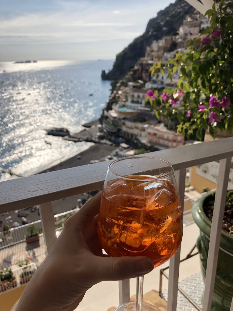 an aperol spritz with the ocean in the background